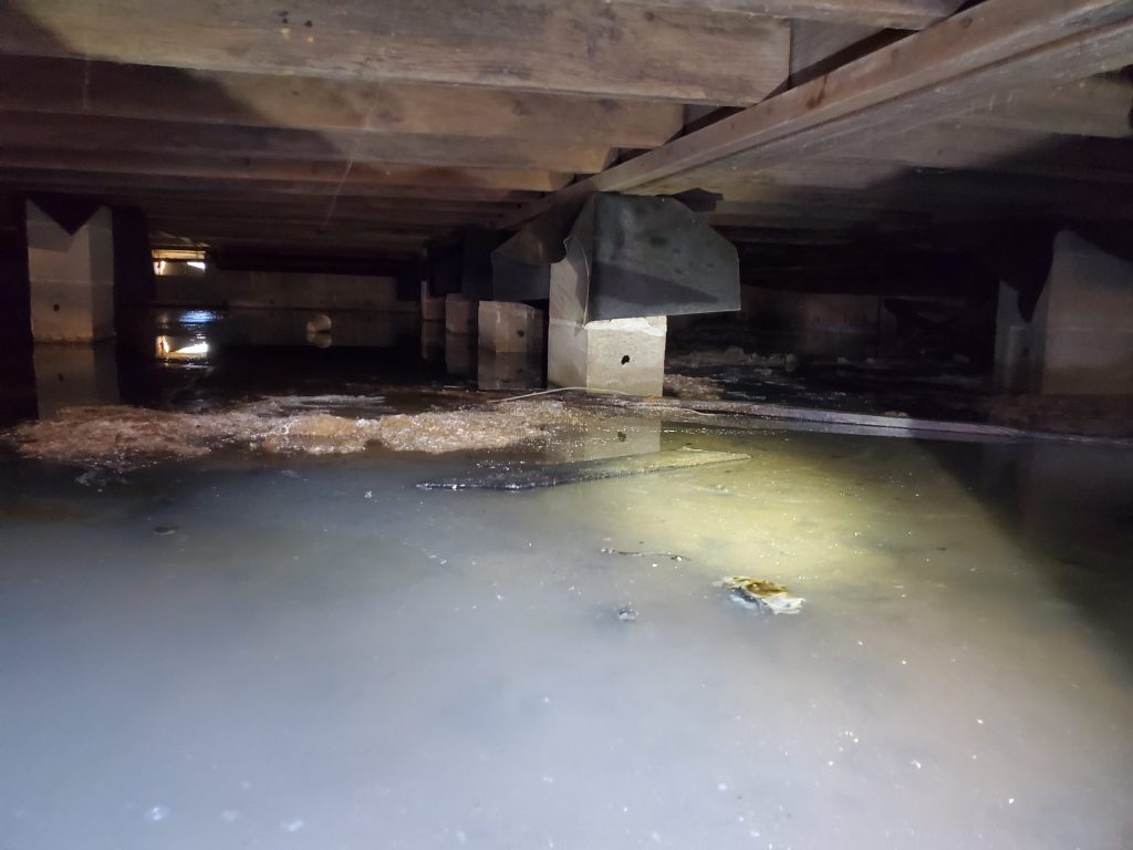 Standing water in a flooded crawl space after a Salt Lake City storm